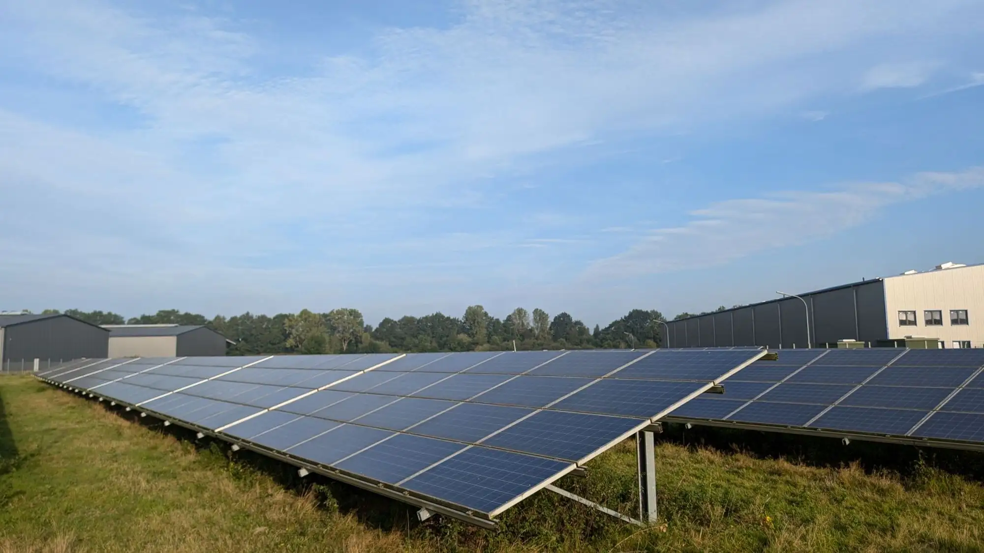 Ground-mounted solar array beside a commercial building