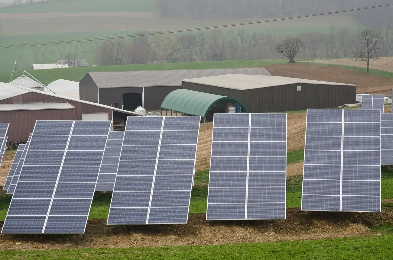 Ground-mounted solar arrays beside farm buildings